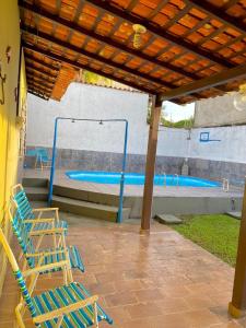 a group of chairs sitting under a pavilion next to a swimming pool at Casa Mosqueiro, Praia do Farol e Chapéu Virado in Mosqueiro