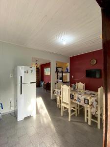 a kitchen with a table and a white refrigerator at Casa Mosqueiro, Praia do Farol e Chapéu Virado in Mosqueiro