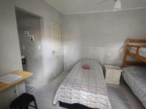 a small bedroom with a bed and a desk at Quarto Paulínia 2 in Paulínia