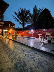 a patio with tables and chairs next to a wall at Pousada NativaMar in Guaratuba