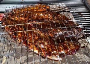 a bunch of food is cooking on a grill at Casa Obe in Yolina