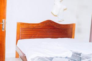 a bed with a wooden headboard in a room at Davidson's guest house in Kayonza