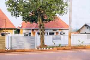 a white fence in front of a house at Davidson's guest house in Kayonza