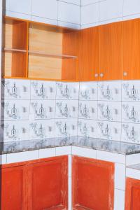 a kitchen with red and white tile on the wall at Davidson's guest house in Kayonza