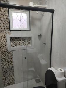 a bathroom with a shower and a toilet and a window at Quarto Paulínia 2 in Paulínia +1 photo