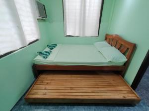 a small bed in a room with a window at Urban Serenity Home in Puerto Princesa City