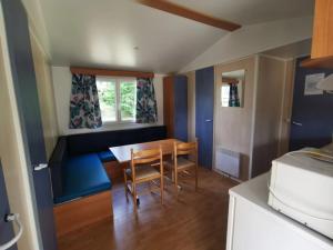 a small kitchen with a table and chairs in a room at ZEcamping 4 étoiles animaux acceptés avec piscine chauffée toboggan et tennis in Ucel
