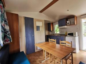 a kitchen with a wooden table and chairs in a room at ZEcamping 4 étoiles animaux acceptés avec piscine chauffée toboggan et tennis in Ucel