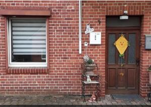 a brick building with a door and two cats sitting on a shelf next to it at One-bed room Mariensee in Neustadt am Rübenberge