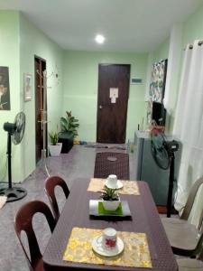 a dining room with a table and chairs and a door at Urban Serenity Home in Puerto Princesa City