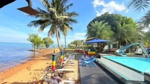 a swimming pool next to a beach with a water slide at เกาะช้าง พูลวิลล่า วิวทะเล 2 in Trat