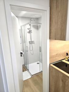 a shower with a glass door in a bathroom at Apartmány ALMA Šumiac in Šumiac +30 photos