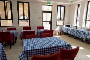 a restaurant with blue and white tables and chairs and windows at New Gate Hostel in Jerusalem