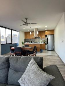 a living room and kitchen with a couch and a table at Deluxe Loft Air Conditioning Downtown Parking in Tepatitlán de Morelos