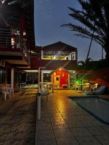 a patio with a pool and tables and a building at Pousada NativaMar in Guaratuba