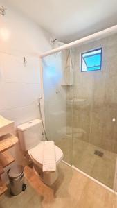 a bathroom with a toilet and a glass shower at CASARÃO SUíTES MARAGOGI in Maragogi