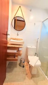 a bathroom with a toilet and a mirror at CASARÃO SUíTES MARAGOGI in Maragogi