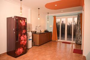 a kitchen with a refrigerator with flowers on it at Kieh Beachfront Villa in Mandrem