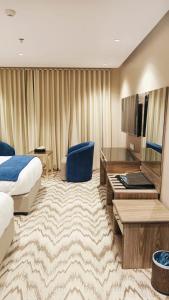 a hotel room with a bed and a desk at فندق بفنPuffin hotel in Qaryat al ‘Ulyā