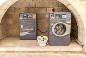 a washing machine sitting next to a brick wall at New Gate Hostel in Jerusalem