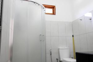 a bathroom with a shower and a toilet at Coral Waves Inn - Pasikuda in Kalkudah