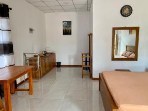 a living room with a bed and a mirror at Coral Waves Inn - Pasikuda in Kalkudah +16 photos