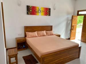 a bedroom with a bed with a wooden head board at Coral Waves Inn - Pasikuda in Kalkudah