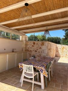 a patio with a table and chairs under a wooden ceiling at Trulli Dafani in Ostuni