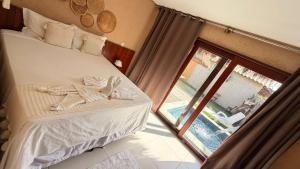 a bedroom with a bed and a sliding glass door at Chalés Milagres Beach in São Miguel dos Milagres +34 photos