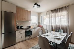a kitchen with a table with chairs and a refrigerator at Deli Home in Kastoria