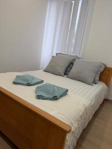 a bed with two green pillows on top of it at L'Appart Chaleur in Oyonnax