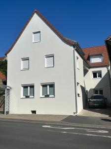 a white house with a car parked in front of it at Schön, praktisch & zentrale Lage in Bergrheinfeld