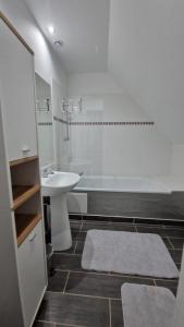 a bathroom with a sink and a tub and a toilet at La désirée in Blangy-sur-Bresle +32 photos