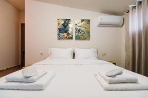 a bedroom with a white bed with two towels on it at Deli Home in Kastoria
