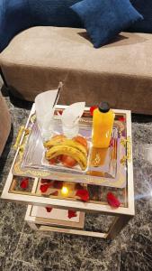 a tray of food on a table in front of a couch at فندق بفنPuffin hotel in Qaryat al ‘Ulyā