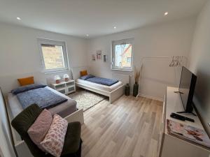 a small room with two beds and a television at Schön, praktisch & zentrale Lage in Bergrheinfeld