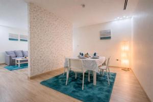 a dining room with a white table and chairs at Al Basem Hotel in Amman