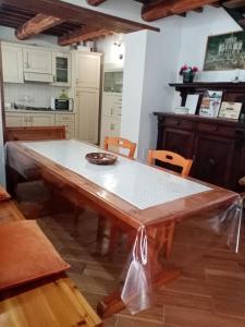 a kitchen with a large wooden table in a room at Al Nido Del Passero 1 in Greccio