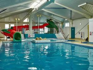 a swimming pool with a slide and a large swimming pool at Stylish large static caravan gold rated 3BR Slp 8 Thorness Bay in Porchfield