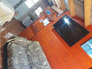 a living room with a couch and a flat screen tv at De Férias na Fronteira in Xuí