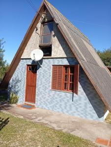 a small house with a brown door and windows at De Férias na Fronteira in Xuí
