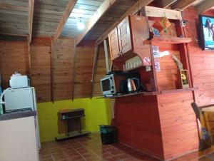 a small kitchen with a microwave and a refrigerator at De Férias na Fronteira in Xuí