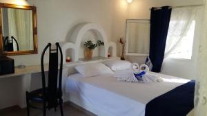 a bedroom with a bed with two towels on it at Anatoli Studios in Skhoinoussa