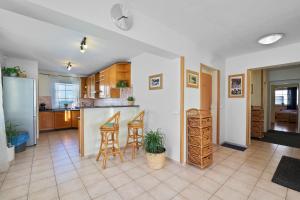 a kitchen and living room with a counter and stools at King size apartmán Pension Monika in Špindlerův Mlýn