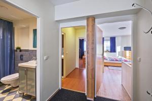 a bathroom with a sink and a toilet and a bedroom at King size apartmán Pension Monika in Špindlerův Mlýn +20 photos