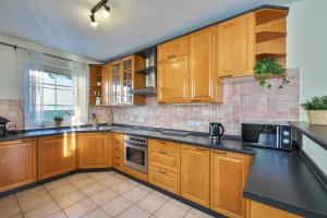 a kitchen with wooden cabinets and black counter tops at King size apartmán Pension Monika in Špindlerův Mlýn