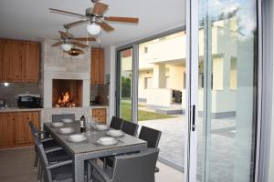 a kitchen and dining room with a table and chairs at Villa Majra in Valbandon