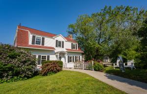 a white house with a gate and a yard at The Colony Hotel Kennebunkport in Kennebunkport