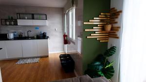 a living room with a kitchen with a wooden shelf on the wall at BENAMAR HOUSE in Quarteira