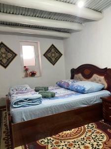 a bedroom with a bed with two stuffed animals on it at Hotel Zukhritdin in Bukhara